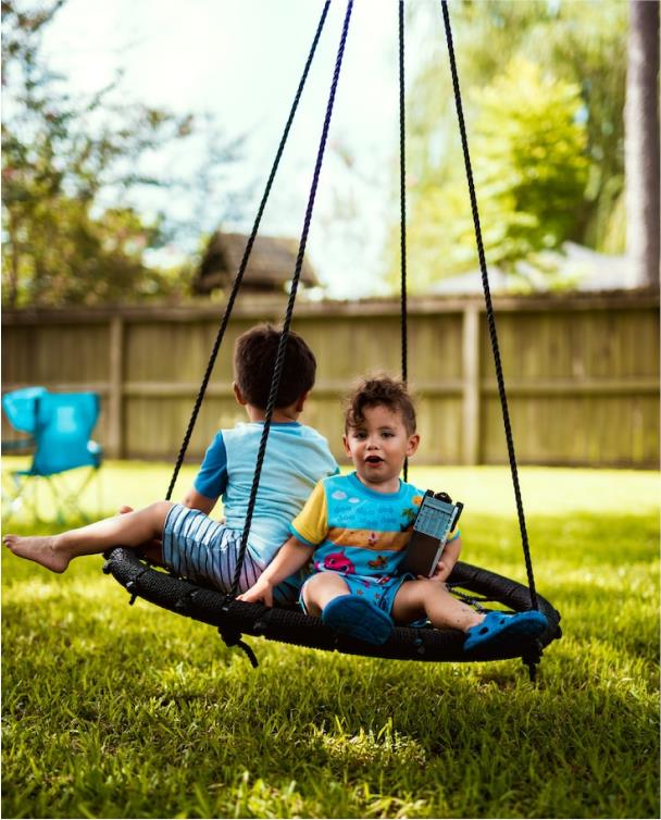 Deux enfants se balancent sur une balançoire nid